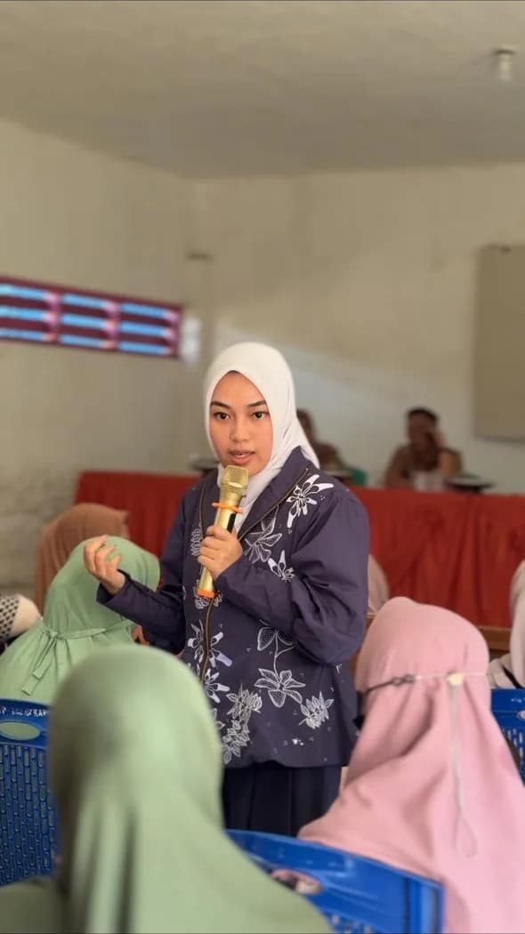 Fasilitator perempuan menyampaikan materi kepada peserta komunitas